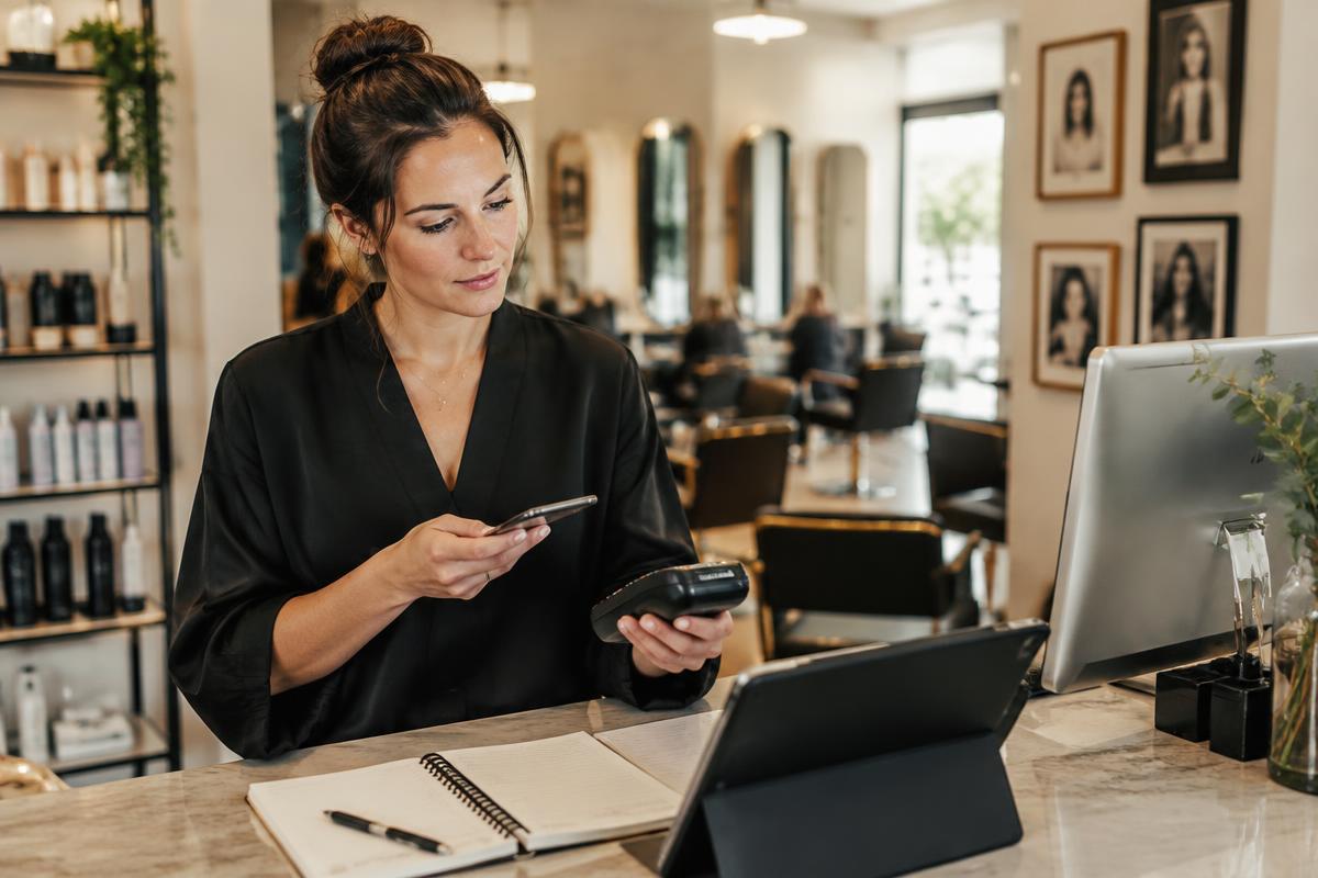 Salon owner checking card sales and business accounts
