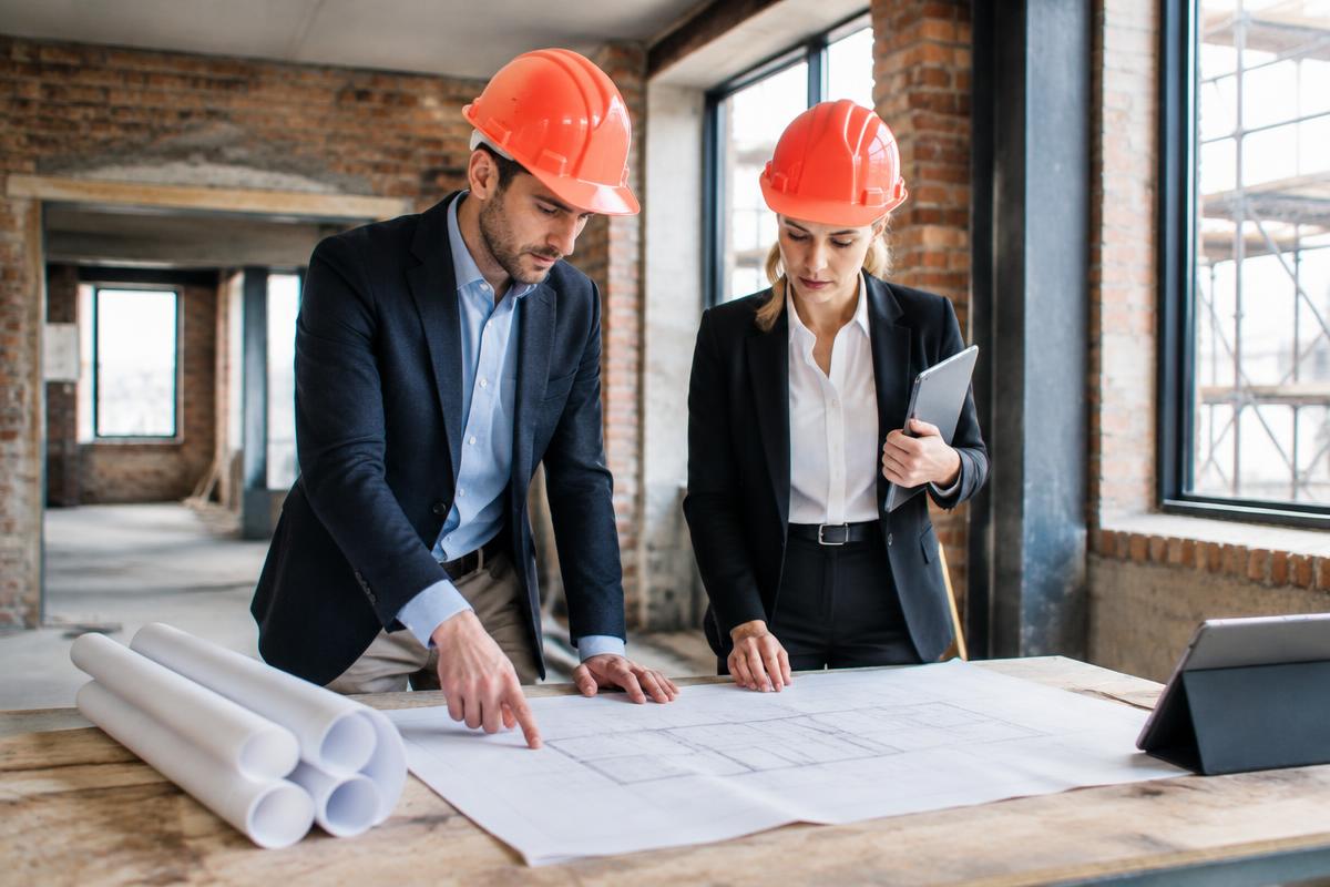 Property developer and surveyor reviewing a renovation plan